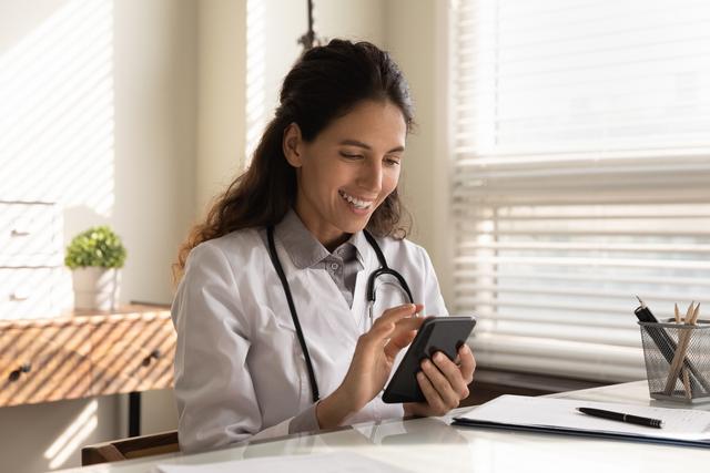 female-european-adult-doctor-consultation-room-using-smartphone-print (1)