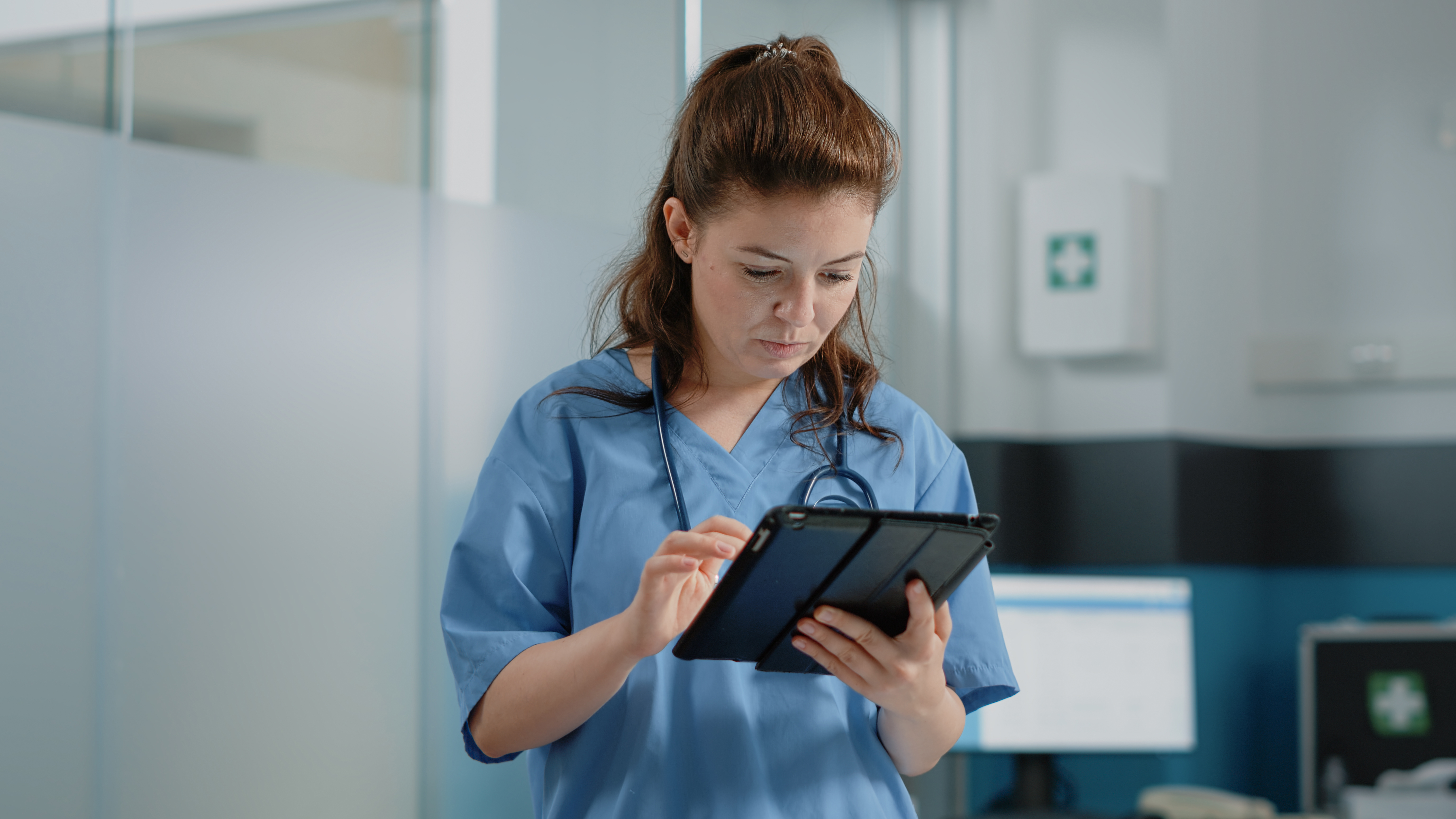female-european-adult-nurse-clinic-searching-on-her-tablet-web